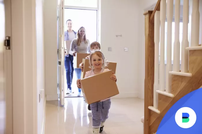 gyerekek rohannak be az új házukba dobozokkal a kezükben